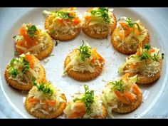 small appetizers are arranged in a circle on a white plate with green garnishes