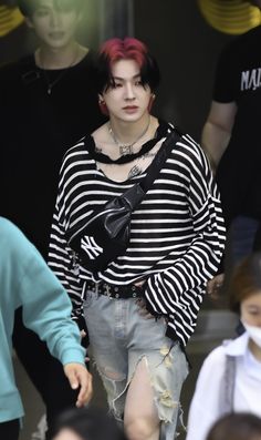 a woman with red hair and black and white striped shirt is walking down the street