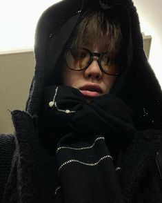 a young boy wearing glasses and a black hoodie