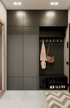 a walk in closet with two coats hanging on the wall and some shoes next to it