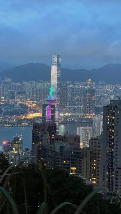 the city skyline is lit up with bright lights and skyscrapers in the foreground