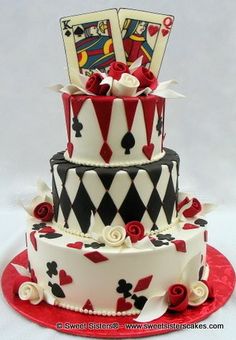 a three tiered cake with playing cards on top