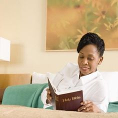 a woman reading a book on her bed