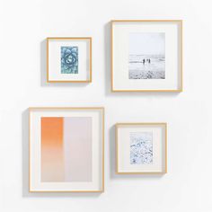 three framed photographs hang on the wall above two other frames, one with an orange and blue ombretta