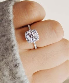 a woman's hand with a diamond ring on it