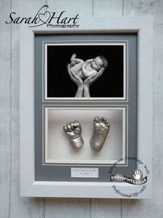 a baby's hand and foot casts in a shadow box with a white frame