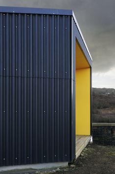 a black and yellow building with a sky background