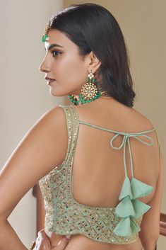 This 3-piece set features a green Titan Silk lehenga choli with 10 meters of flair and a Butterfly Net dupatta. It is standard cancan and canvas attached. The entire set is detailed with dori, mirror, zari and sequins embroidery. The blouse is sleeveless, round necked with back dori and tassels, and measures 0.8 meter. The lehenga is floor-length and flared. Dry-cleaning is recommended for this set. Customizations are available upon checkout; simply add your measurements in the “Order Notes” box Blouse With Dori Design, Dori For Lehenga, Back Dori Designs, Dories For Blouse, Blouse Dori Designs, Dori Blouse Designs, Blouse Designs Back Side, Dori Designs, Dori Blouse