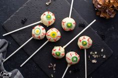 halloween cake pops with white frosting and sprinkles on a black surface