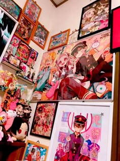 there are many pictures on the wall in this room, including anime characters and dolls