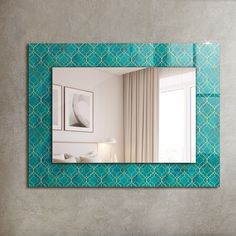 a mirror that is on the side of a wall with a blue and white pattern