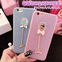 two phone cases with bows and chains on them, one is pink and the other is blue