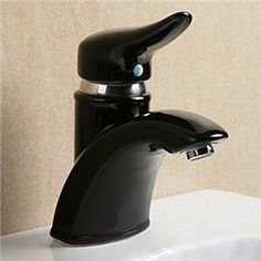 a black faucet sitting on top of a white sink next to a wall