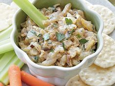 a plate with crackers, celery, carrots and tortilla chips