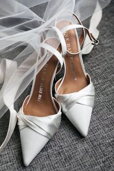 the bride's wedding shoes and veil are sitting on the floor next to each other