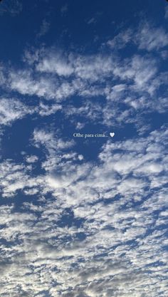 the sky is filled with white clouds and there is a small heart in the center