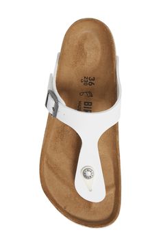 Available in an array of colors, this flip-flop is fitted with a molded footbed and topped with a Birko-Flor strap, cut from fabric with a leather-like finish. The toe piece is made of flexible resin, anatomically designed to fit comfortably between the toes, and the soft suede insole absorbs moisture and feels great against the skin. Adjustable strap with buckle closure Contoured footbed with arch support Synthetic upper/leather and textile lining/synthetic sole Imported Women's Shoes White Synthetic Flip Flops With Single Toe Strap, White Synthetic Single Toe Strap Flip Flops, White T-strap Sandals With Leather Footbed, White Sandals With Arch Support And Single Toe Strap, Casual White T-strap Flip Flops, White T-strap Flip Flops, Adjustable White Flip Flops With Arch Support, White Adjustable T-strap Flip Flops, Birkenstock Papillio