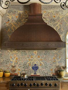 a stove top oven sitting inside of a kitchen next to a wall papered wall