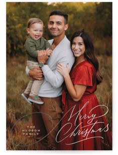 a man and woman holding a baby in their arms with the words merry christmas written on it