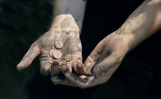 two hands holding some coins in their palms