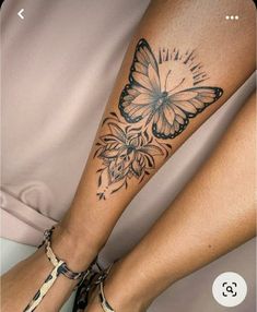 a woman's leg with a butterfly tattoo on her left arm and the bottom part of her legs