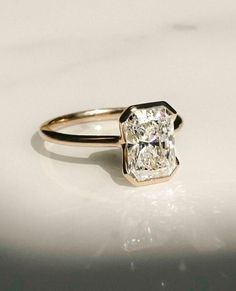 a diamond ring sitting on top of a white surface