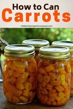 jars filled with carrots sitting on top of a wooden table