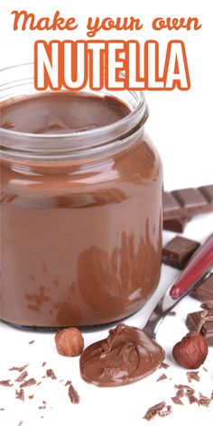 a jar filled with chocolate and nuts on top of a white table next to a spoon