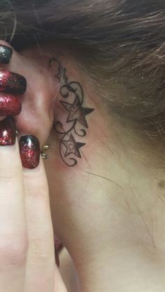 a close up of a person with a tattoo on her neck and behind their ear