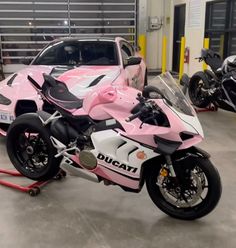 a pink and white motorcycle parked in a garage