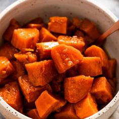 a white bowl filled with cooked sweet potatoes