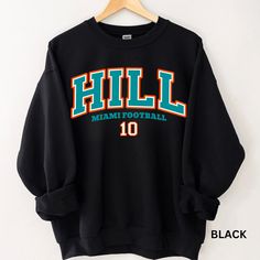 Perfect sweatshirt for Miami football and Tyreek Hill fans this season! Ideal for any situation, a unisex heavy blend crewneck sweatshirt is pure comfort. These garments are made from polyester and cotton. This combination helps designs come out looking fresh and beautiful. The collar is ribbed knit, so it retains its shape even after washing. There are no itchy side seams on these sweaters.  .: 50% cotton, 50% polyester .: Medium-heavy fabric (8.0 oz/yd² (271.25 g/m .: Loose fit .: Sewn-in label .: Runs true to size CARE INSTRUCTIONS: -Please wash all clothing items INSIDE OUT to preserve the design. -Please wash all clothing items on cold, and dry on Medium- low heat. -DO NOT IRON. -DO NOT TIE DYE. **Please check our color and size charts before you place your order. If you have any ques Pre-shrunk Crew Neck Sweatshirt For School Spirit, Black Fan Apparel Sweatshirt For Football Season, Black College Sweatshirt For Football Season, Black Crew Neck Sweatshirt For Football Season, Black Football Season Sweatshirt With Team Name, Black Sweatshirt With Team Name For Football Season, Black Sweatshirt With Football Team Name, Black School Spirit Sweatshirt With Crew Neck, Black Sweatshirt For Football Season Streetwear