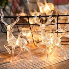 two lighted deer figurines sitting on top of a wooden table