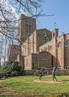 two statues in front of a large brick building