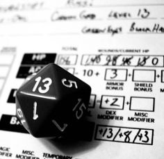 a black and white photo of a dice on top of some paper with the numbers