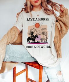 Unleash your playful side with our cheeky "Save a Horse, Ride a Cowgirl" T-shirt! Crafted from the softest 100% combed and ringspun Airlume cotton, this tee promises not only supreme comfort but also a flawless fit. Perfect for those who love a touch of sass and a lot of softness, this shirt is designed to make a statement while keeping you cozy all day long. Whether you're out on a casual day with friends or just lounging around, this shirt is the perfect combination of fun and comfort. Its lig Ring-spun Cotton Graphic Tee, Day With Friends, Pride Tshirts, Home T Shirts, Brand Ambassador, A Horse, Horse Riding, Love A, Piece Of Clothing