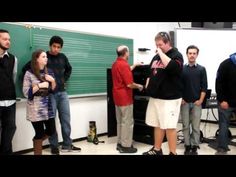 a group of people standing in front of a blackboard