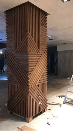 a tall wooden structure sitting in the middle of a room with construction tools around it