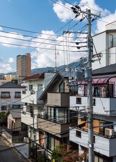 an overhead view of houses and power lines in the city with mountains in the background