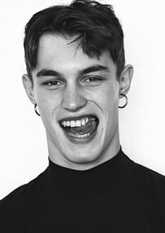 a black and white photo of a young man with braces on his teeth smiling