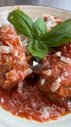 meatballs covered in marinara sauce and garnished with fresh basil on top