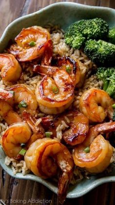 shrimp, broccoli and rice in a bowl on top of a wooden table