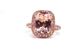 a fancy ring with an oval cut pink morganite surrounded by pave diamond halos