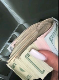 a person is holding money in their hand