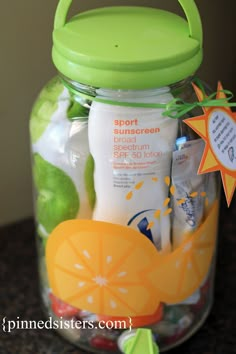 a glass jar filled with lots of different types of baby care products on top of a counter