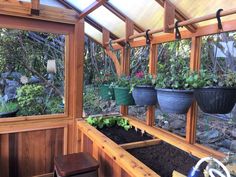 several potted plants are hanging from the side of a wooden structure in a garden