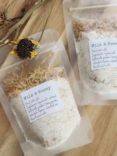 two bags of white rice sitting on top of a wooden table next to a sunflower