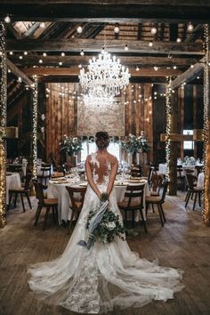 a bride sitting on the floor in front of a chandelier at her wedding