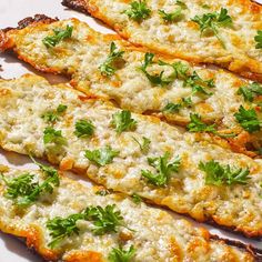 several pieces of bread with cheese and parsley on top