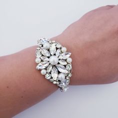 Beautiful Bridal Bracelet . Made with Crystals and pearls set in rhodium plated metal. This bracelet is about 1 1/4 inches wide . It is an open bangle so it will fit any size. Pearls are available in white and ivory. the pictures are taken with ivory pearls. Matching earrings are available at this link: https://www.etsy.com/listing/721180019/vintage-pearl-rhinestone-drop-earrings?ref=shop_home_active_1 Matching hair comb: https://www.etsy.com/listing/703183928/vintage-oval-shape-crystal-rhinesto Silver Beaded Bracelets For Wedding, Silver Beaded Bangle Bracelets For Wedding, Silver Jeweled Bracelets For Weddings, Silver Beaded Bangle For Party, Silver Pearl Bracelet For Party, Silver Beaded Pearl Bracelet For Party, Silver Bangle Pearl Bracelet For Weddings, Silver Pearl Bangle For Wedding, Silver Crystal Pearl Bracelet With Beads